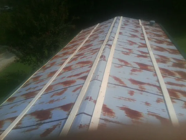 Rusted metal roof panels with new wood purlins before replacement — Storm Damage Roof Repair in Lee Center by Roofing Brothers
