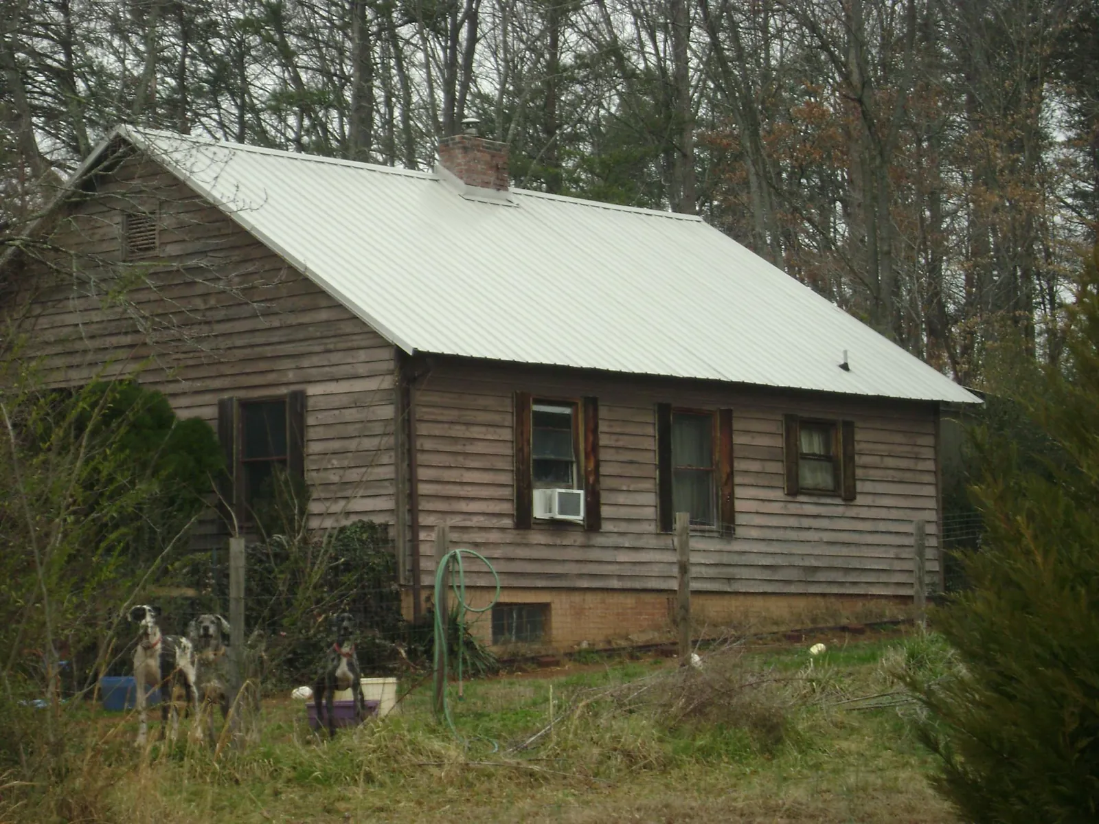White metal roof on an old wood sided farmhouse, from a Metal Roof Installation job in Lee Center